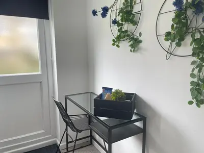 a glass table with a chair and plants on the wall at Cambridge Stay Cozy home with Wi-Fi, Parking Perfect for 2 in Cherry Hinton