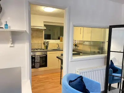 a kitchen with a blue chair in a room at Cambridge Stay Cozy home with Wi-Fi, Parking Perfect for 2 in Cherry Hinton