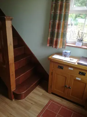 a room with a wooden staircase and a window at Meadow Farm Cottage in Norwich