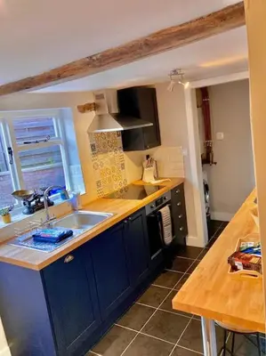 a kitchen with blue cabinets and a sink and a counter at Almond Cottage Clare - 2 bedroom English Cottage in Clare