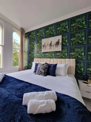 a bedroom with a large bed with blue walls at Two Bedroom Mansion House Apartment By AZ Luxury Stays Newmarket With Parking And WiFi in Newmarket