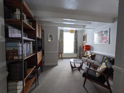 a living room with a couch and bookshelves at Arts House in Harwich