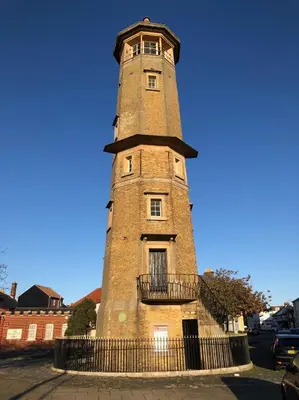 a tall brick tower with a fence around it at Arts House in Harwich
