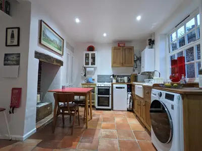 a kitchen with a table and a washing machine at Arts House in Harwich
