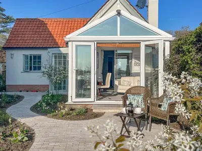 a conservatory with a table and chairs on a patio at Quayside Cottage Uk33899 in Waldringfield