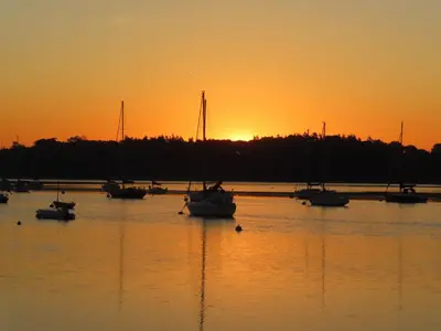 a group of boats in the water at sunset at Quayside Cottage Uk33899 in Waldringfield