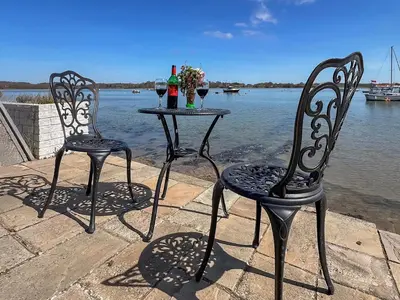 two chairs and a table with two bottles and glasses at The Boathouse Uk33900 in Waldringfield