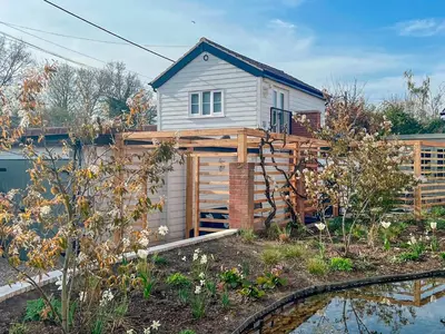 a small white house with a wooden fence at The Boathouse Uk33900 in Waldringfield