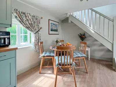 a kitchen with a table and chairs and a staircase at The Boathouse Uk33900 in Waldringfield