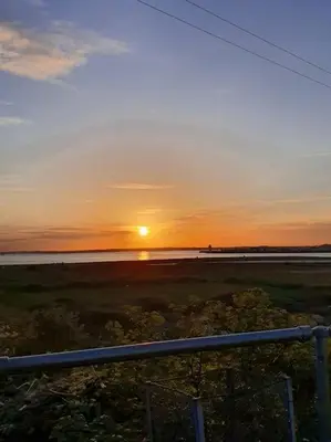 a sunset over the ocean with the sun in the sky at The Tiny Sea Gem in Jaywick Sands