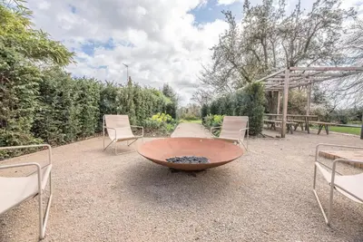 a circular table with chairs and a fire pit at The Limes, Benhall in Saxmundham