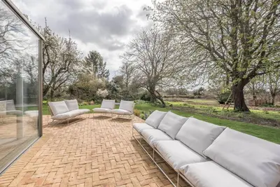 a living room with a white couch and a patio at The Limes, Benhall in Saxmundham