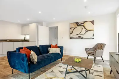 a living room with a blue couch and a table at Tailored Stays - Water Street Apartments in Cambridge