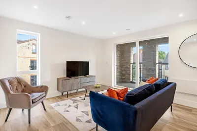 a living room with a couch and a tv at Tailored Stays - Water Street Apartments in Cambridge