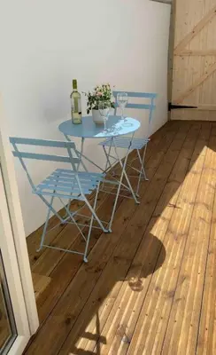 a blue table with two chairs and a bottle of wine at Lovely 1 bed flat 200 metres from beach in Walton-on-the-Naze
