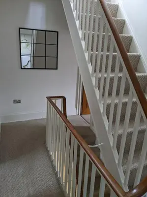 a white staircase with a mirror on the wall at Beautiful Georgian townhouse in central Colchester in Colchester