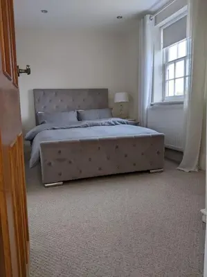 a bedroom with a large bed with a large window at Beautiful Georgian townhouse in central Colchester in Colchester