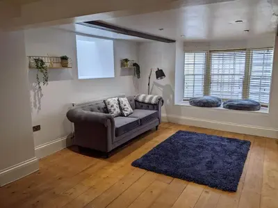 a living room with a couch and a window at Beautiful Georgian townhouse in central Colchester in Colchester