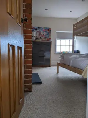 a bedroom with a bed and a brick wall at Beautiful Georgian townhouse in central Colchester in Colchester