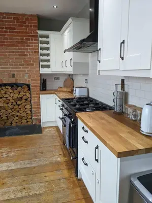 a kitchen with white cabinets and a stove top oven at Beautiful Georgian townhouse in central Colchester in Colchester