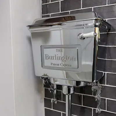 a toilet in a bathroom with a brick wall at Georgina in Lavenham