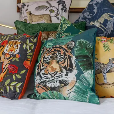 a pile of pillows with tigers on them on a bed at Georgina in Lavenham