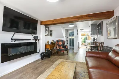 a living room with a couch and a tv at Georgina in Lavenham