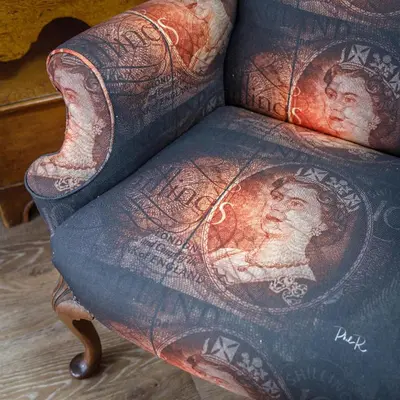 a chair with a painting of a man on it at Georgina in Lavenham