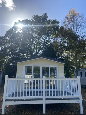 a white bench in front of a house at KellysHolidayHomes 26 Willerby 2 bedrooms caravan in Weeley