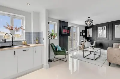 a kitchen and living room with a couch and a table at Modern Apartment in Wymondham in Wymondham