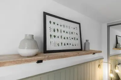 a shelf with a picture and a vase on it at Modern Apartment in Wymondham in Wymondham