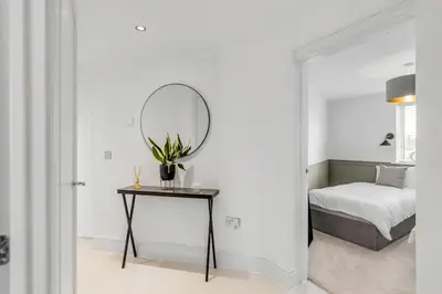 a bedroom with a mirror and a table with a bed at Modern Apartment in Wymondham in Wymondham