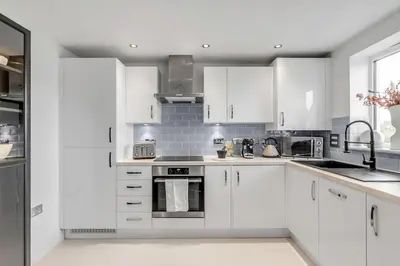 a white kitchen with white cabinets and appliances at Modern Apartment in Wymondham in Wymondham