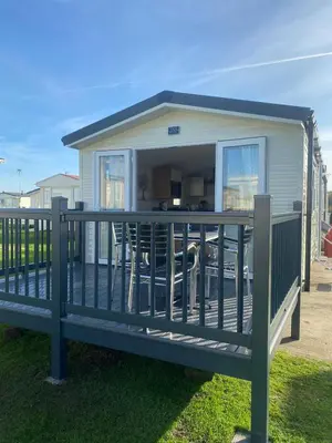 a mobile home with a deck with a large window at Modern 3 bedroom caravan near the beach in Walton-on-the-Naze
