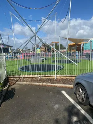 a fence in front of a parking lot with a car at Modern 3 bedroom caravan near the beach in Walton-on-the-Naze