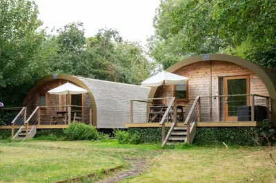 a small house with a circular roof and a patio at Cosy and eco-friendly cabins next to 16th century pub in Newmarket