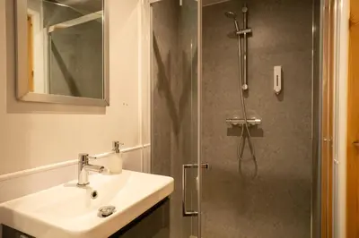 a bathroom with a sink and a shower at Cosy and eco-friendly cabins next to 16th century pub in Newmarket