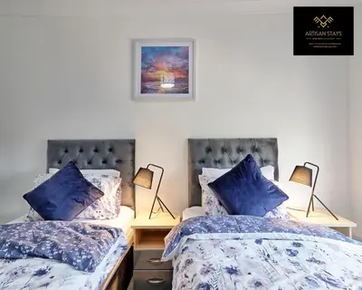 a bedroom with two beds with blue pillows at Deluxe Apartment in Southend-On-Sea by Artisan Stays I Free Parking I Sleeps 4 in Southend-on-Sea