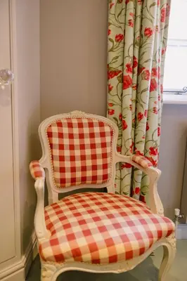 a plaid chair in a room with a window at The Crown, Bildeston in Bildeston