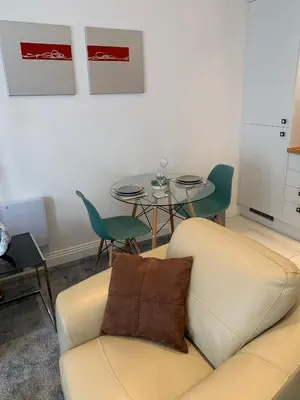 a living room with a couch and a table at The office at the old Forge in Great Wymondley