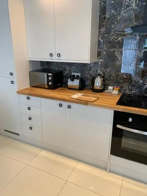 a kitchen with white cabinets and a counter top at The office at the old Forge in Great Wymondley