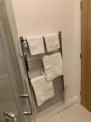 a towel rack in a bathroom with white towels at The office at the old Forge in Great Wymondley