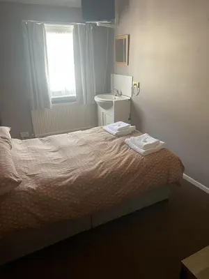 a bedroom with a bed with a sink and a window at Shakers Inn in Harwich