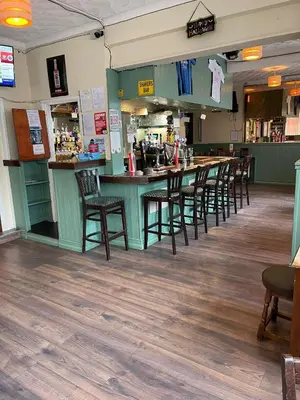 a bar in a restaurant with a row of chairs at Shakers Inn in Harwich