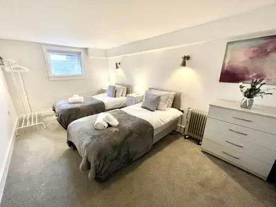 a bedroom with two beds and a dresser at Fantastic convenient 2 Bedroom 2 bathroom Perfect for Stansted Airport, 3 minute walk to Bishops Stortford Train Station! in Bishops Stortford