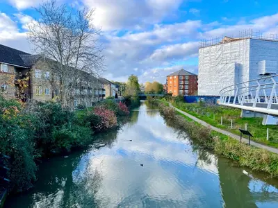 a river in a city with buildings and a bridge at Fantastic convenient 2 Bedroom 2 bathroom Perfect for Stansted Airport, 3 minute walk to Bishops Stortford Train Station! in Bishops Stortford