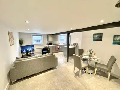 a living room with a couch and a table at Fantastic convenient 2 Bedroom 2 bathroom Perfect for Stansted Airport, 3 minute walk to Bishops Stortford Train Station! in Bishops Stortford