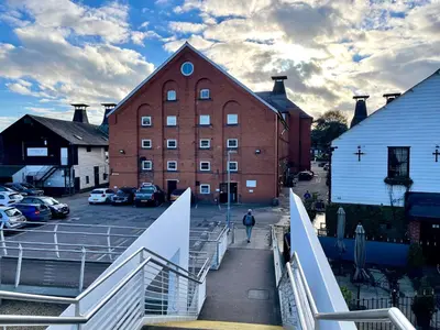 a person walking down a bridge over a parking lot at Fantastic convenient 2 Bedroom 2 bathroom Perfect for Stansted Airport, 3 minute walk to Bishops Stortford Train Station! in Bishops Stortford