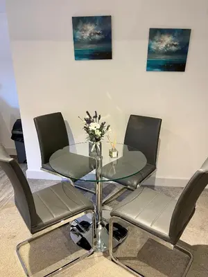 a table with four chairs and a vase of flowers on it at Fantastic convenient 2 Bedroom 2 bathroom Perfect for Stansted Airport, 3 minute walk to Bishops Stortford Train Station! in Bishops Stortford
