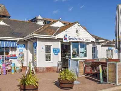 a sandwich shop with potted plants in front of it at Secretseaview in West Mersea